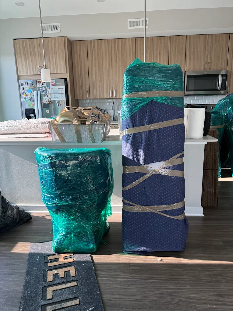 Wrapped chair and tall furniture staged in a modern kitchen ready to load