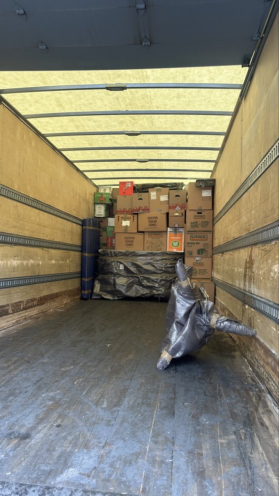 Box truck loaded with boxes, wrapped mattress and rolled rug