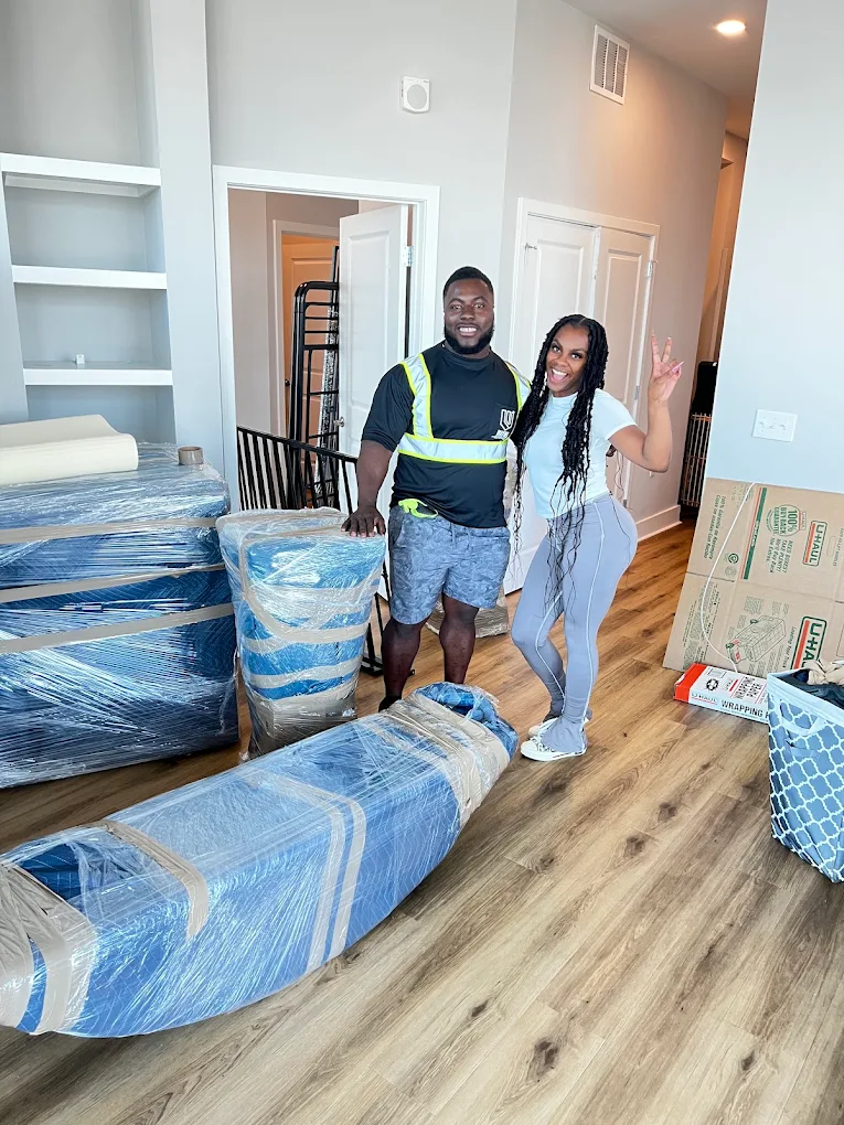 Wayne posing with a happy customer beside her wrapped bed frame and mattress