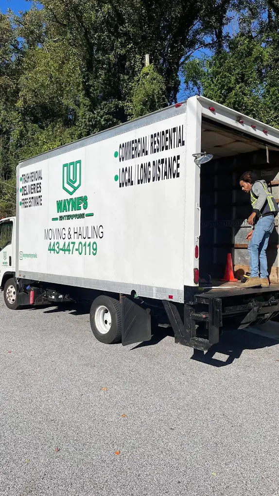 The white Wayne's Enterprise box truck with green lettering, loading ramp down