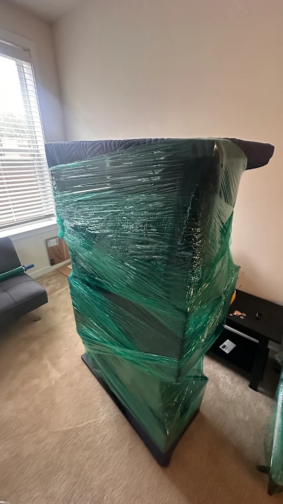 A tall stack of drawers and cases wrapped as a single green column ready to roll out