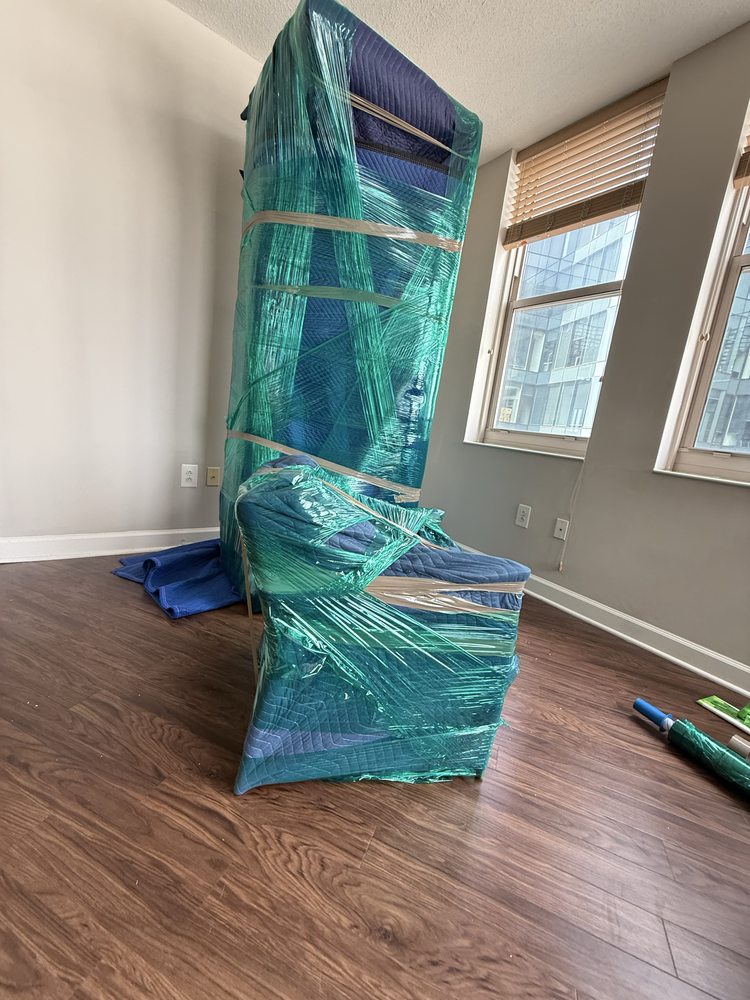 Mattress and box spring wrapped in green stretch wrap